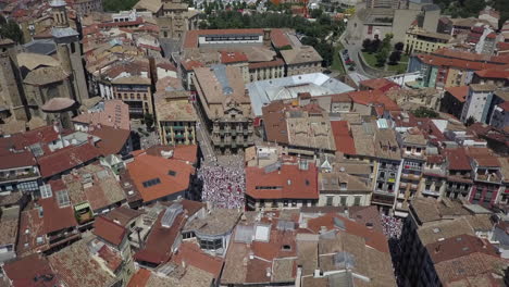 aerial descends to crowd in plaza consistorial in pamplona, spain