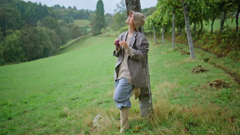 woman enjoying the harvest in a vineyard on a rainy day