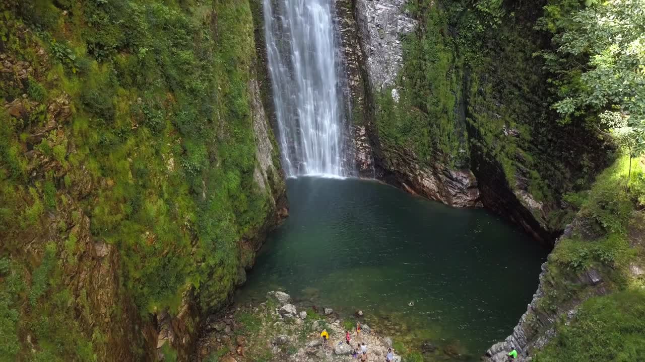 Aerial drone shot flying away, revealing the grandeur of the Segredo waterfall amidst the stunning landscape of Chapada dos Veadeiros, Brazil