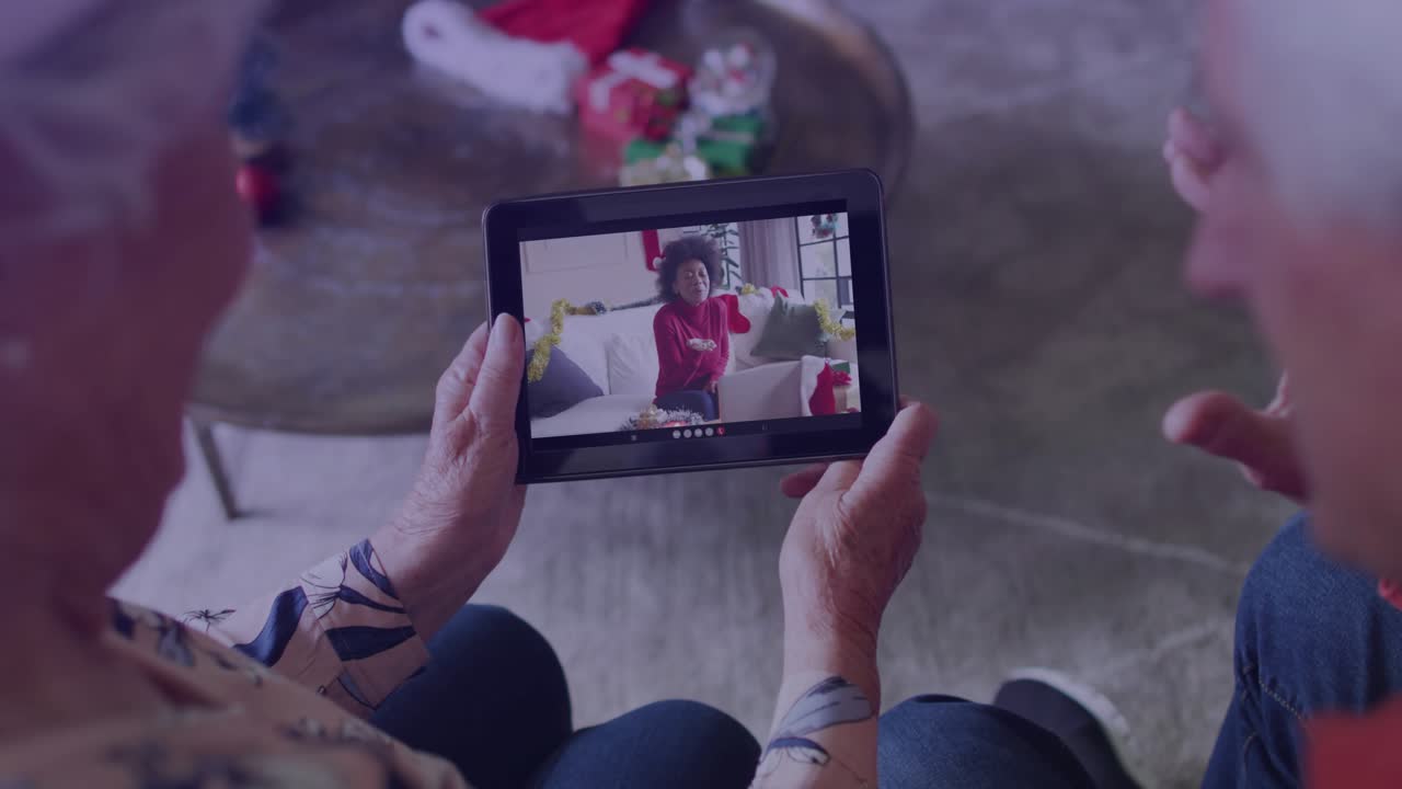Una coppia di anziani avvia una chiamata su tablet per ricevere assistenza tecnica, visualizzando l'host mentre le sovrapposizioni oscurano il tablet