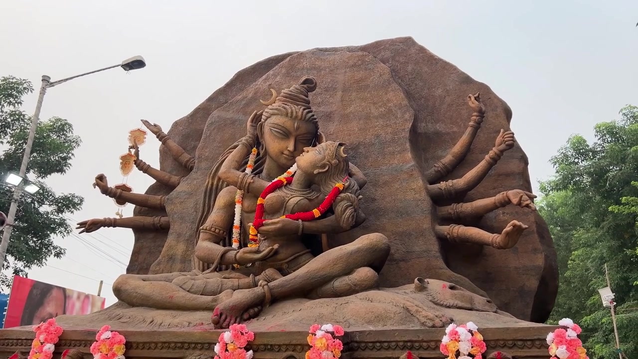 Avgudabild av Maa Durga i Shiv Jis knä med en sorgsen blick vid karnevalståget på Red Road i Kolkata, Indien