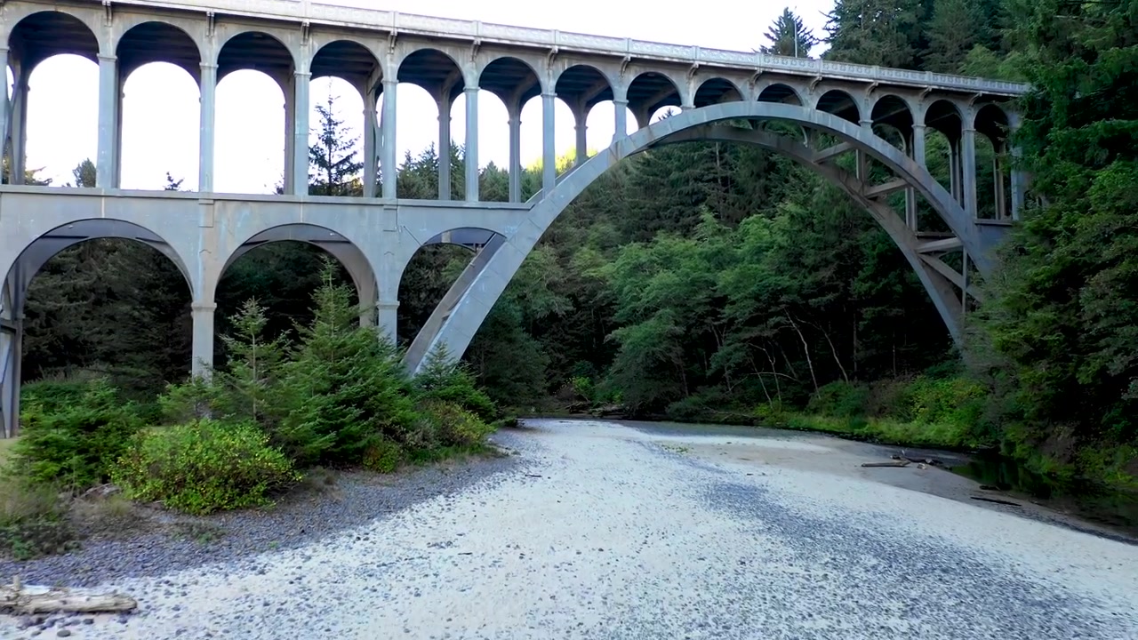 Vista panoramica del ponte e dell'autostrada di Cape Creek in Oregon, circondati da splendidi alberi sempreverdi e cieli blu durante un magnifico tramonto all'ora d'oro