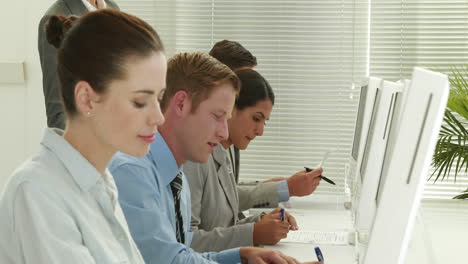 business people writing on paper in call center