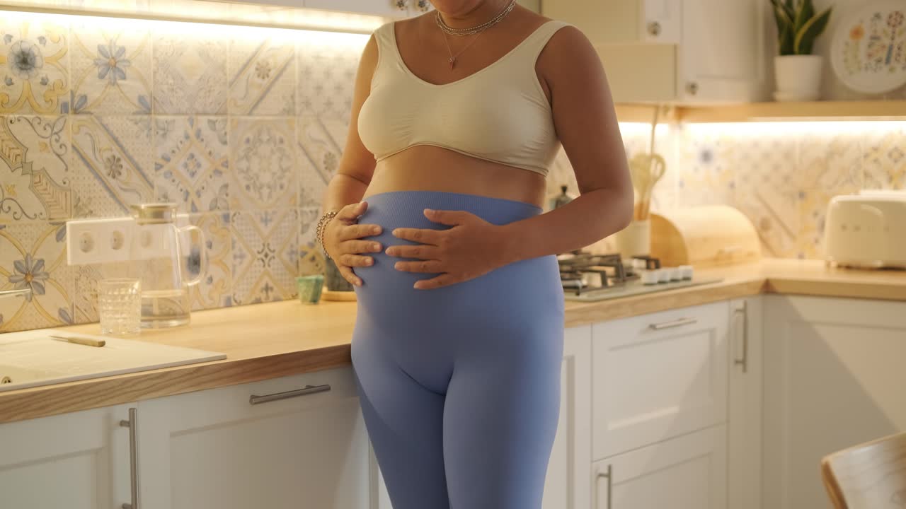 una mujer embarazada disfrutando de su rutina diaria en casa, relajándose en la sala de estar y comiendo en la cocina. la escena destaca la comodidad, la maternidad y los momentos de cuidado personal en un entorno acogedor