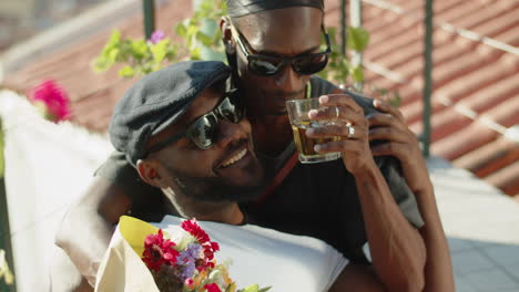 Happy-bearded-gay-lying-on-his-lover-on-rooftop-terrace