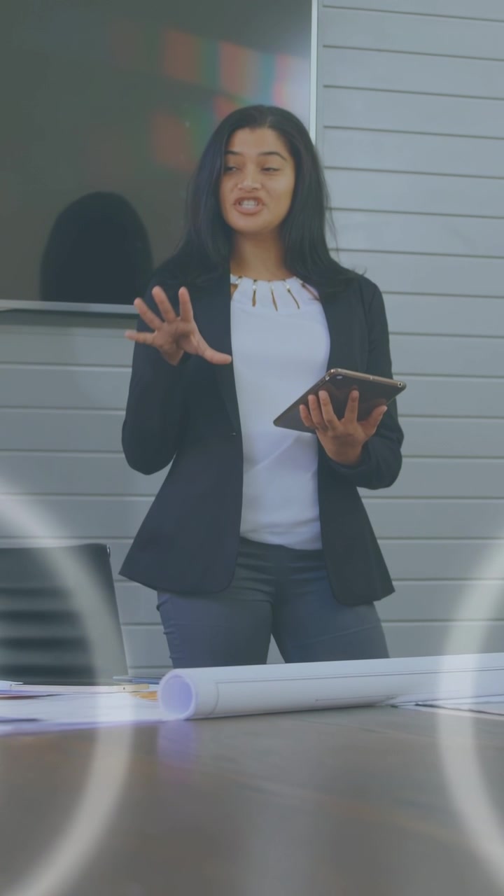 Vertical video: Opening talk woman with tablet gesturing in business meeting, HUD showing plans