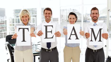 personas de negocios felices sosteniendo páginas deletreando equipo