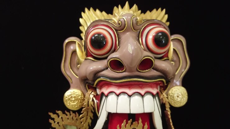 Primo Piano Maschera in Legno di Uomo Festivo con Orecchini d'Oro Topeng Bali Indonesia, Sfondo Nero