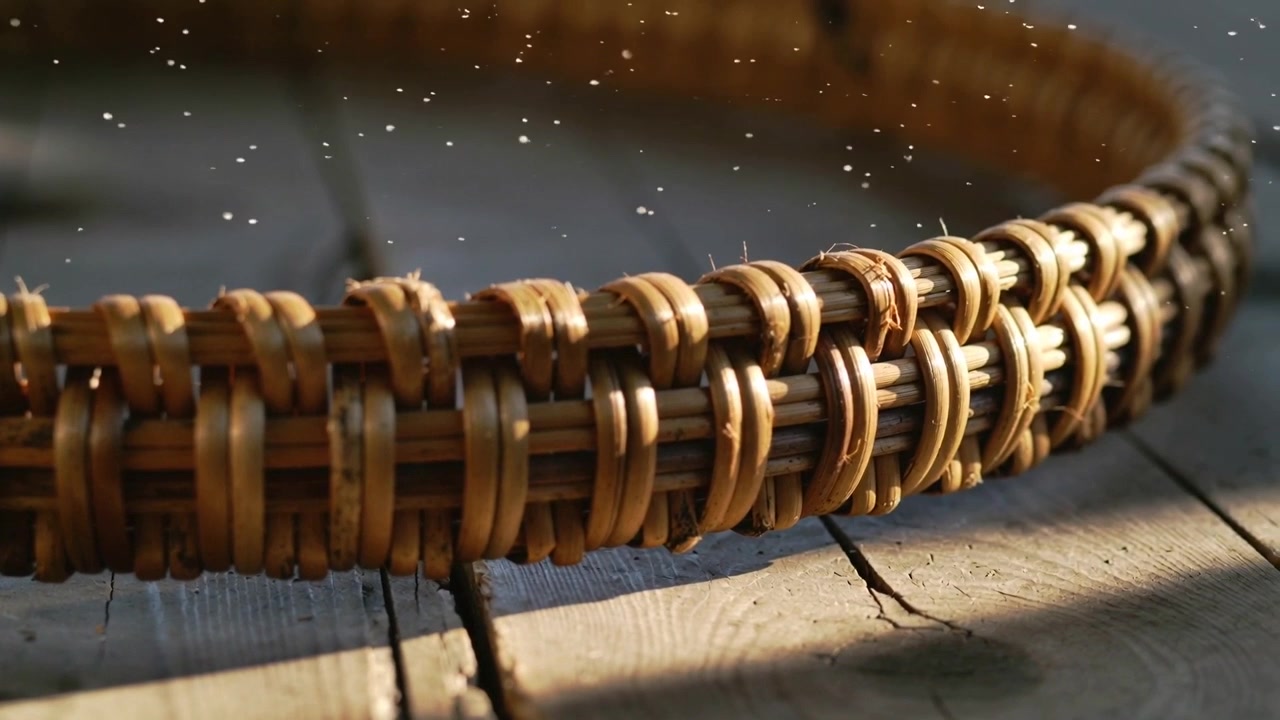 Revealing woven wicker basket rim becoming sharper under sunlight on weathered planks, dust motes
