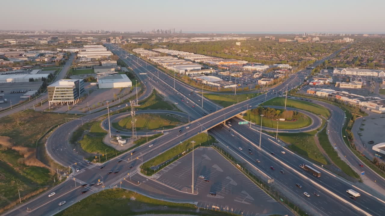 Wide aerial view of highway 401 in Mississauga, Canada, slow motion, capturing the bustling roads and surrounding industrial buildings