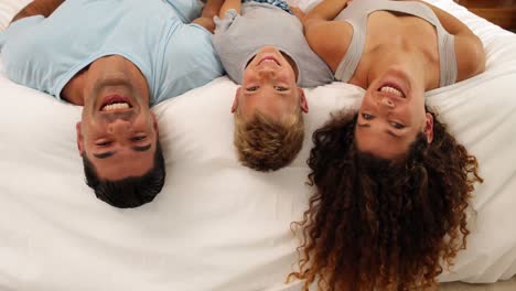 Family-lying-on-bed-posing-for-camera