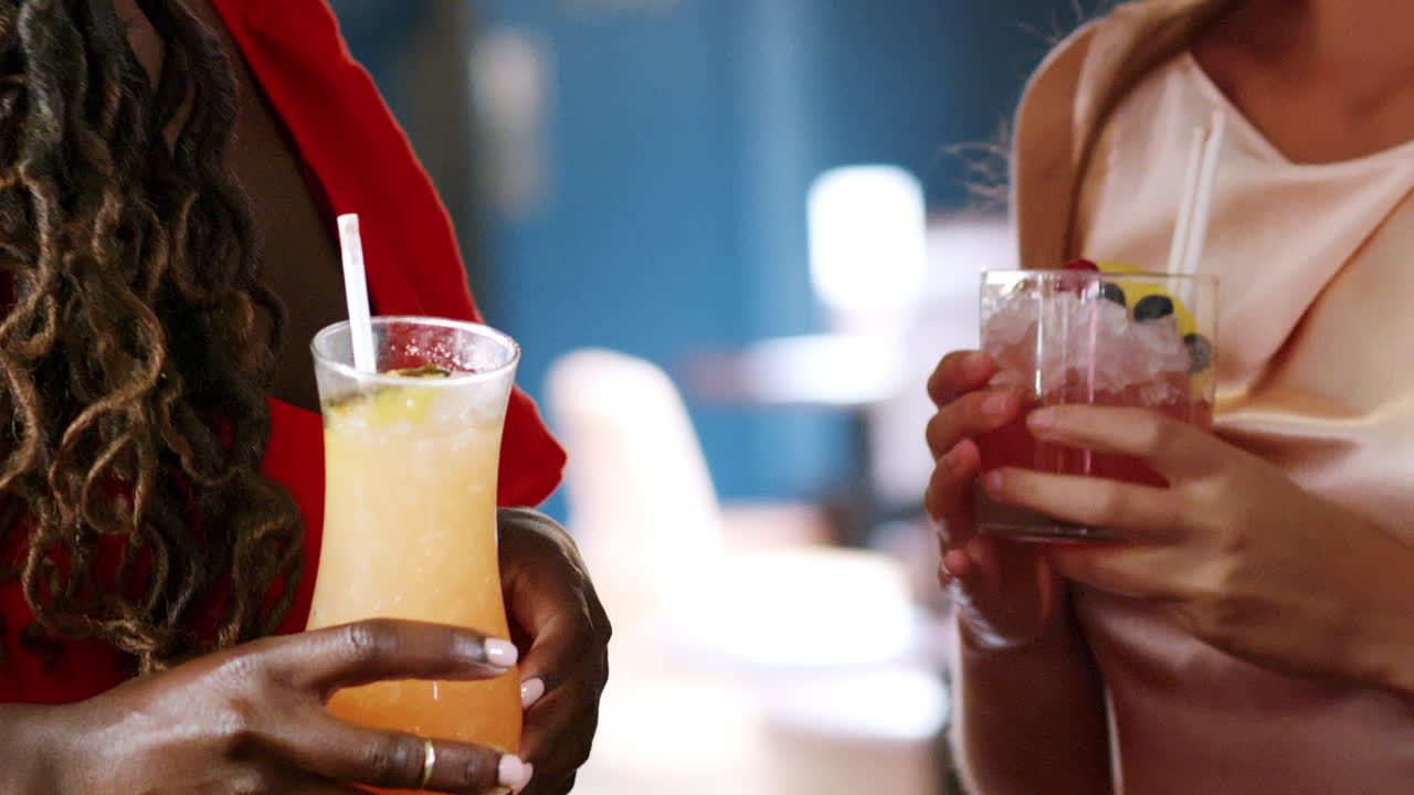 primer plano de amigas reuniéndose para tomar bebidas en un bar de cócteles