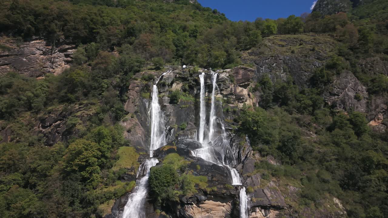 Poderosas cascatas de Acquafraggia caindo por um penhasco rochoso em Valchiavenna, Itália. Drone aéreo.