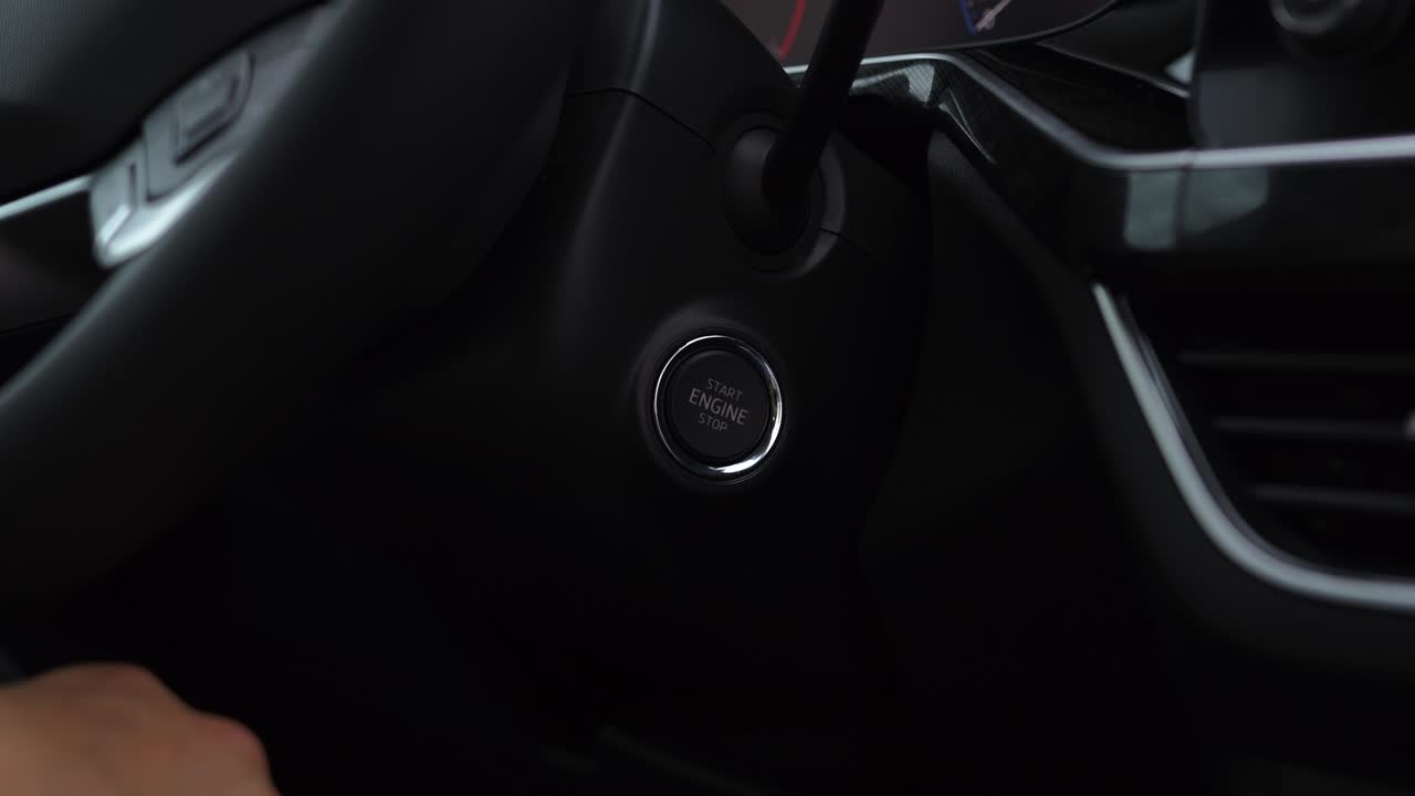 el hombre presiona el botón de arranque y parada con su dedo para arrancar un coche nuevo después de la compra