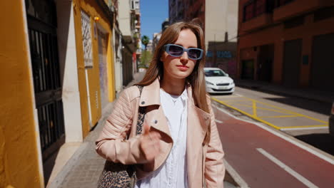woman in a pink leather jacket and stylish sunglasses on a city street