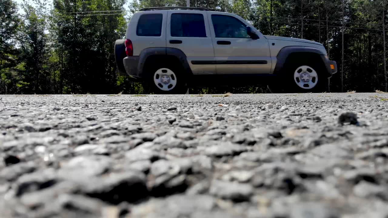 vista aérea de la carretera rural con camiones que viajan con maizales y árboles que rodean un agradable día soleado