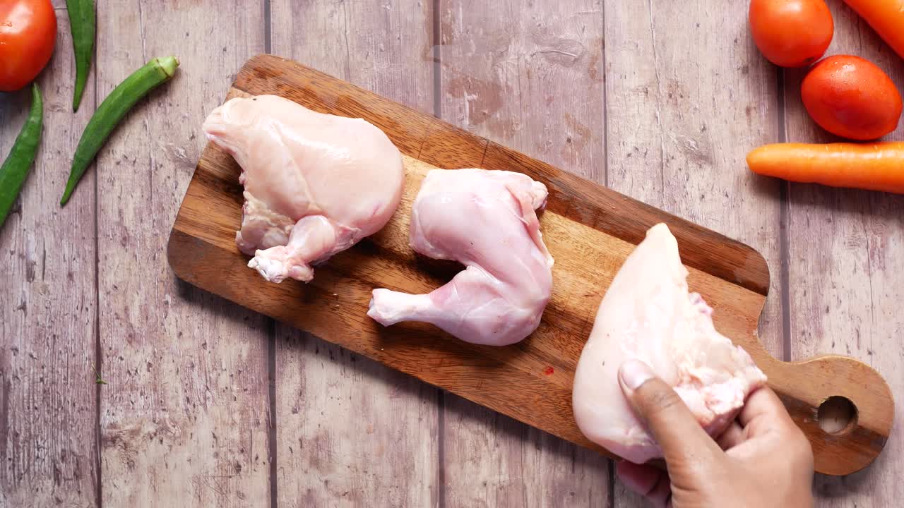 vista de arriba de una pierna de pollo cruda en una tabla de cortar ,