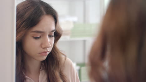 beautiful woman plucking eyebrows with tweezers in mirror at bathroom