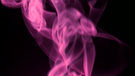 humo rosado que se eleva lentamente giros graciosos hacia arriba. humo de colores que sopla de abajo hacia arriba. primer plano, aislado en fondo negro