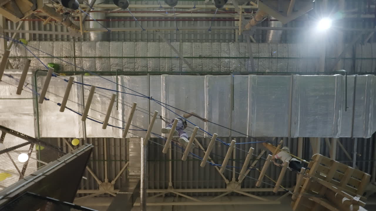 People Navigating an Indoor High Ropes Adventure Course