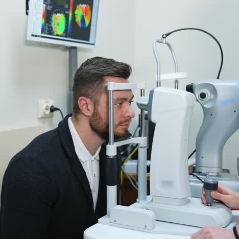 male patient in ophthalmology clinic. selective focus on man`s face while checking vision