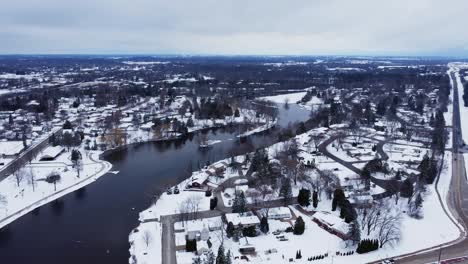 Sobrevuelo-Aéreo-De-Un-Barrio-Suburbano-Cerca-De-Un-Río-En-Invierno