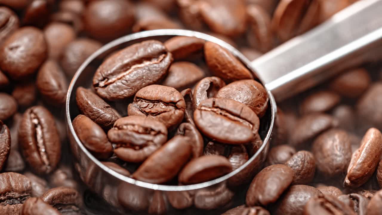Nærbillede af kaffebønner. Duftende kaffebønner ristes, og der kommer røg fra kaffebønnerne.