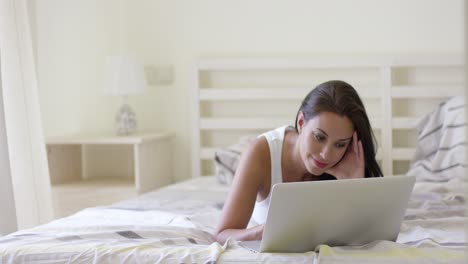 Mujer-Joven-Que-Se-Establecen-En-La-Cama-Usando-Laptop