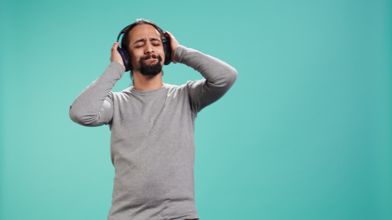 hombre escuchando música fuerte en auriculares estéreo inalámbricos