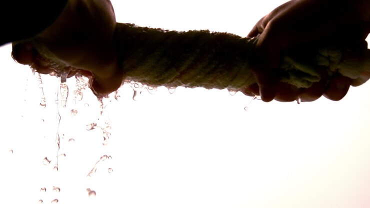 Hands wringing out washrag on white background