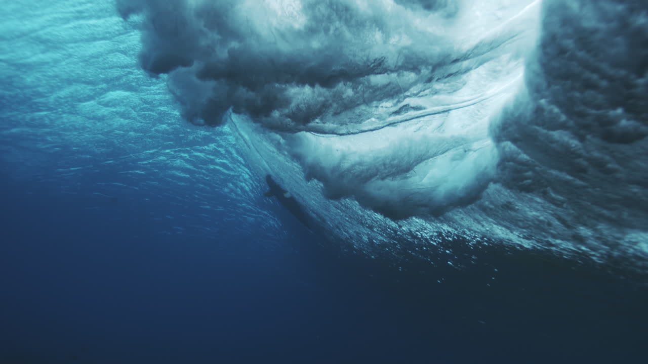 Foam spray and mist throws forward as tendrils grow from vortex, underwater wave