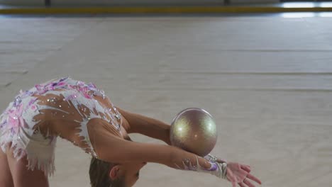 teenage female gymnast performing at sports hall