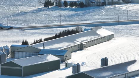 barns at american farm covered in snow during winter