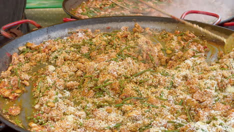 paella de pollo y verduras que se revuelve en una sartén grande en un mercado callejero de edimburgo, edimburgo, lothian, reino unido