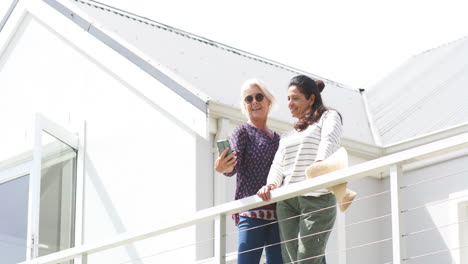 Zwei-Glückliche,-Vielfältige-Seniorinnen-Machen-An-Einem-Sonnigen-Tag-Selfie-Auf-Der-Terrasse,-Zeitlupe,-Kopierraum