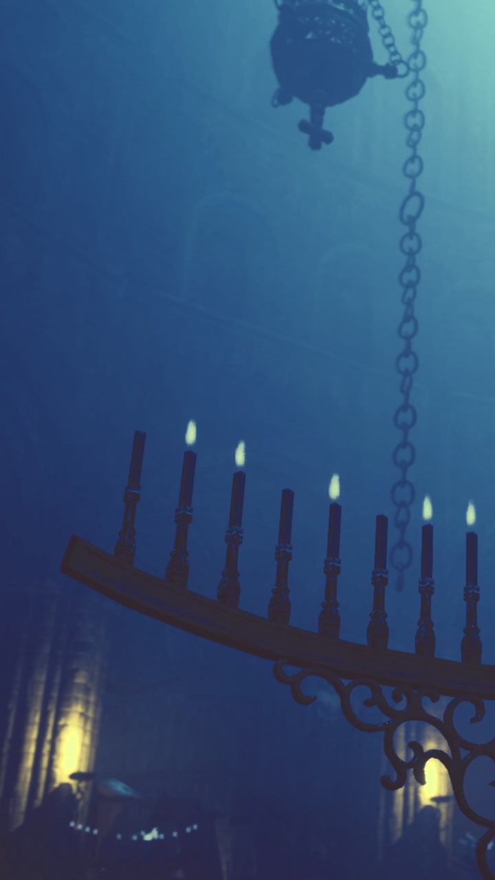 Chandelier hanging in dimly lit space with soft light coming from candles