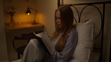 woman writing in a notebook in bed at night