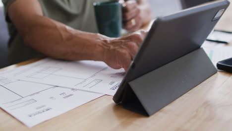 Senior-biracial-man-with-coffee-using-tablet