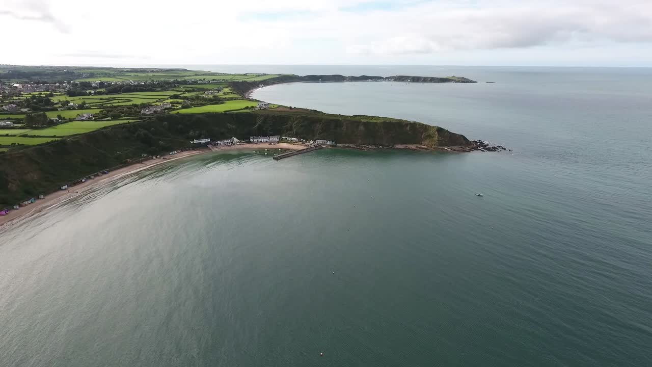 vista aérea que se acerca al puerto y las cabañas de la playa en nefyn con porthdinllaen en la distancia situada en la península de illyn en el norte de gales