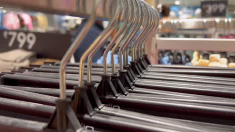 a close up shot of few hangers placed in a queue in a cloth store