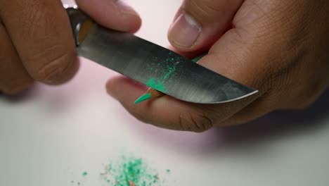 Footage-of-hands-slowly-sharpening-a-pencil-and-some-coloured-pencils-with-a-sharp-knife