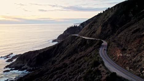 aerial view of bixby bridge in big sur california overlooking the pacific ocean with car at sunset