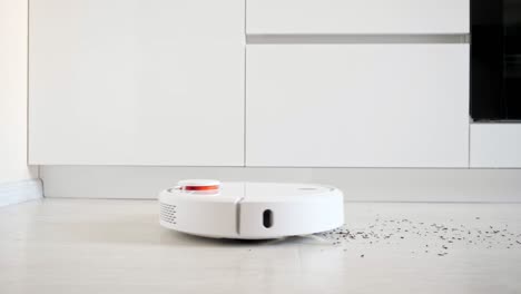robot vacuum cleaner removes scattered litter from floor