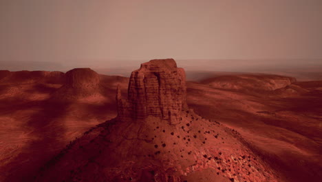 a barren red landscape with a tall rock formation in the center