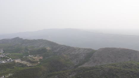 Aerial view of rocky ridges and sparse greenery in Kallar Kahar, Chakwal, under a hazy sky. Chakwal, Pakistan