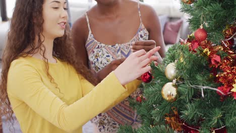 Happy-group-of-diverse-friends-decorating-christmas-tree