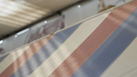 high-resolution slow-motion video of a blue and red striped fabric stretched taut within a metal frame, viewed from an overhead perspective