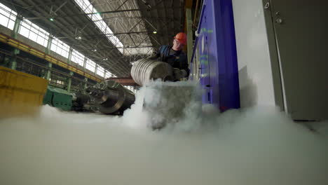 trabajador industrial que maneja líquido criogénico en una fábrica