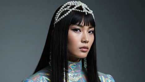 a captivating portrait of a model showcasing a striking combination of high fashion and elegance, adorned with a unique pearl headpiece and holographic attire