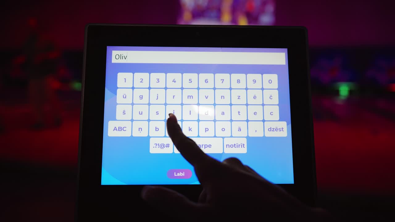 Closeup of hand typing player name Olivia on bowling touchscreen before match